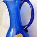 Was bedeutet diese Glassignatur einer alten blauen Glasflasche ?