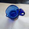 Was bedeutet diese Glassignatur einer alten blauen Glasflasche ?