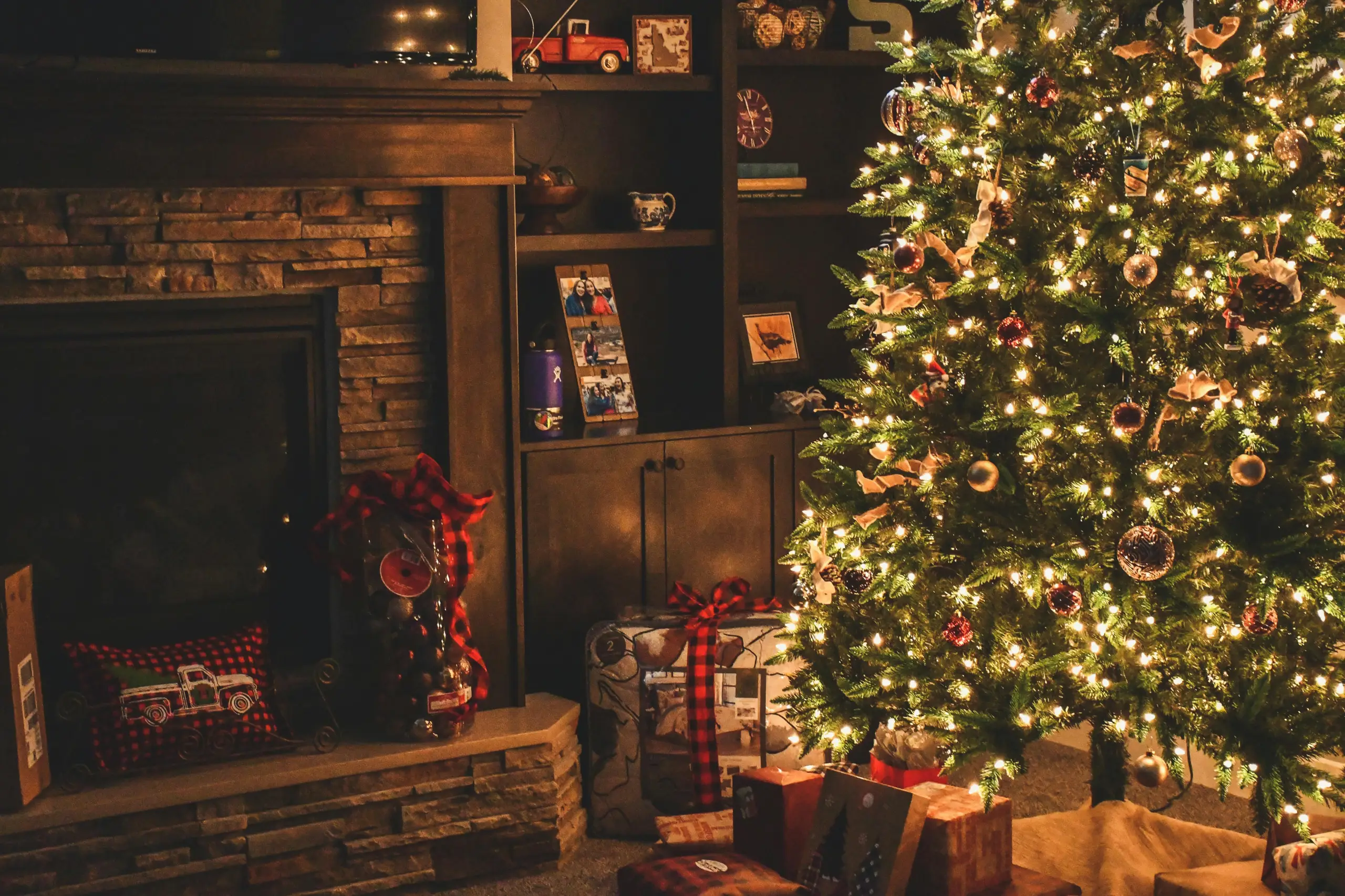 Bild einer weihnachtlichen Kulisse mit Baum, Geschenken und Lichtern