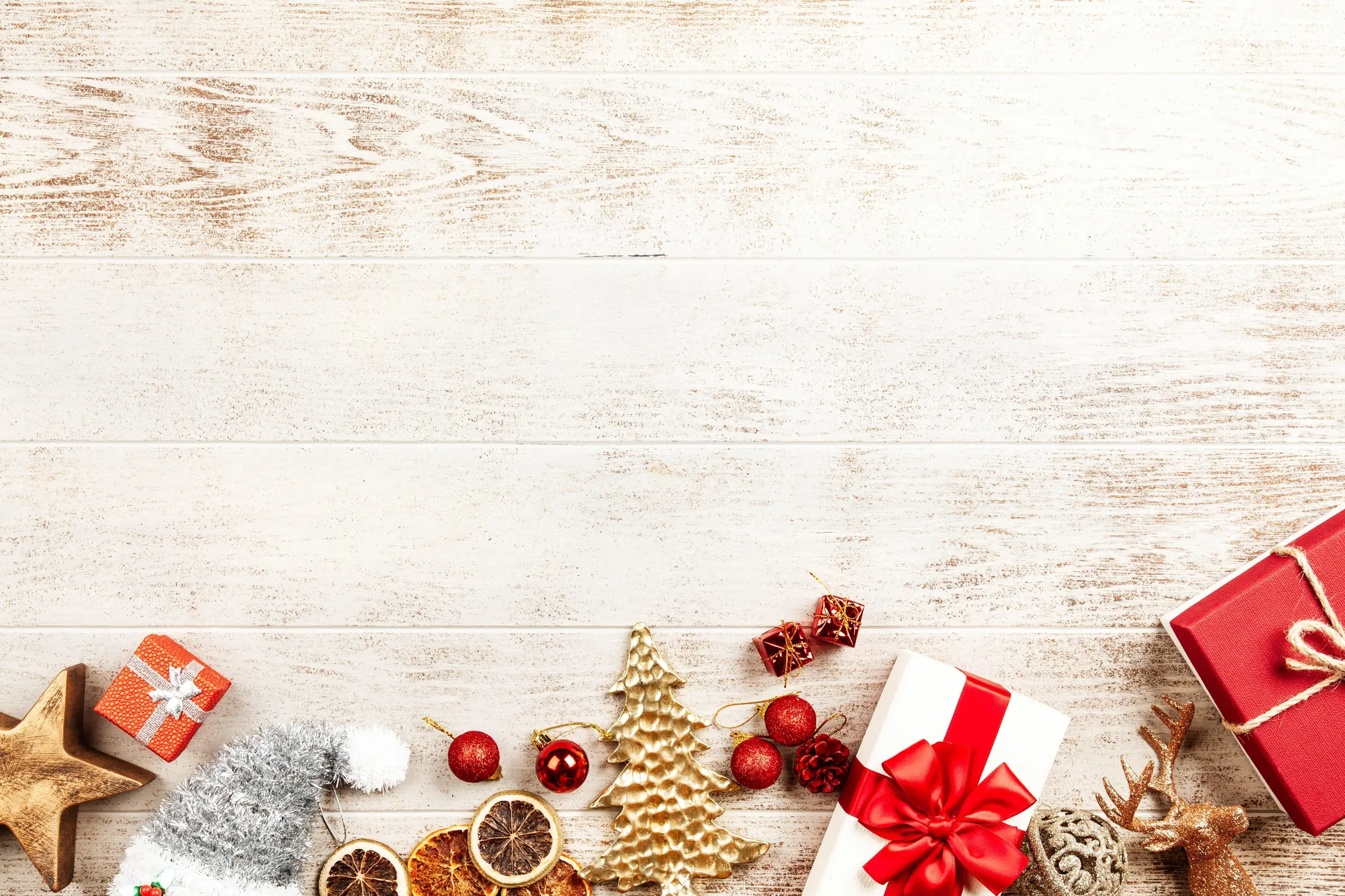 Typisch weihnachtliche Motive wie Geschenke und Tannenbaum nebeneinander 
