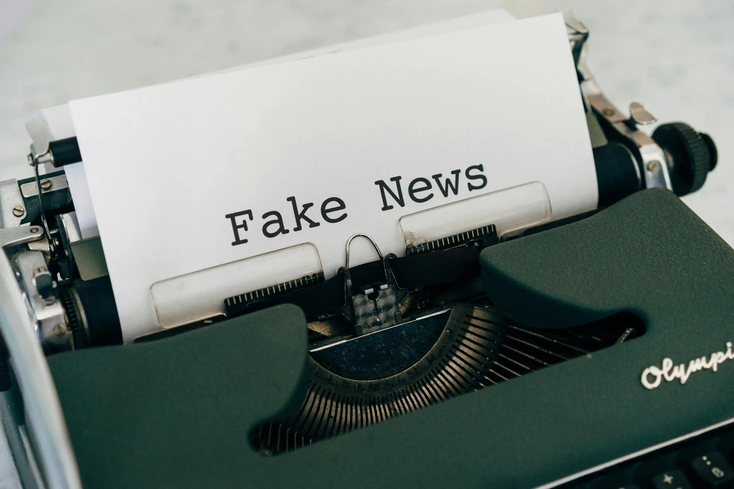 Schreibmaschine mit Papier, auf dem "Fake News" getippt wurde