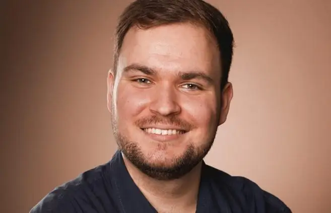 Gestapelte Euro-Münzen mit einer lesenden Miniaturfigur oben drauf