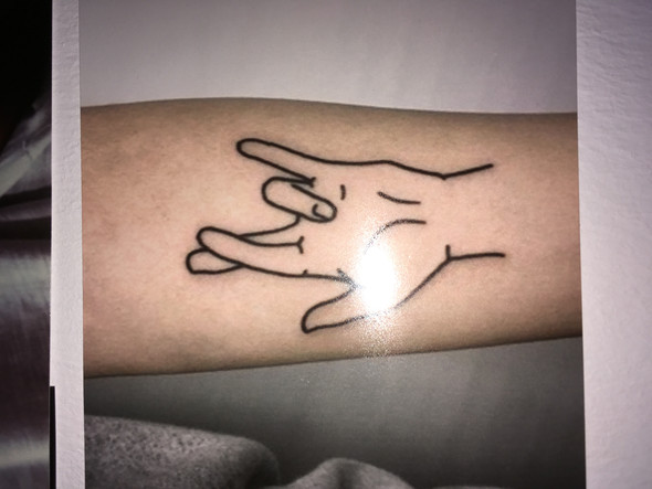 Was für eine Bedeutung kann das überkreutzte Finger Tattoo haben?