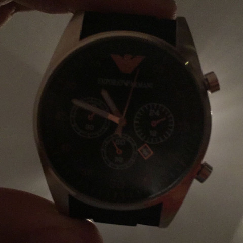 An der Seite in der Mitte fehlt das - (Vergrößern, Armani Uhr, Krone fehlt)
