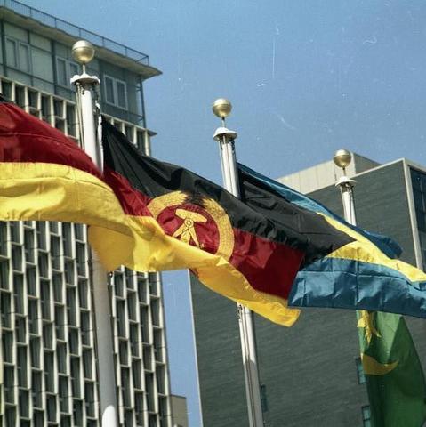 Von links nach rechts: Flagge der BRD, Flagge der DDR, unbekannte Flagge - (Uno, NVA, blauhelmsoldaten)