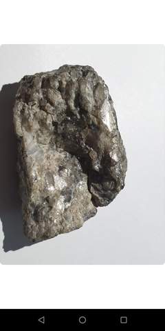 Ich habe diesen stein gefunden in etwa 15 cm tiefe im ufer eines kleinen see's was ist er?er schiemmerd silber als wenn welches eingeschlossen ist?