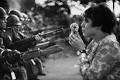 Junge Frau steckt Blume in Waffenlauf - (vietnamkrieg, Symbolbild)