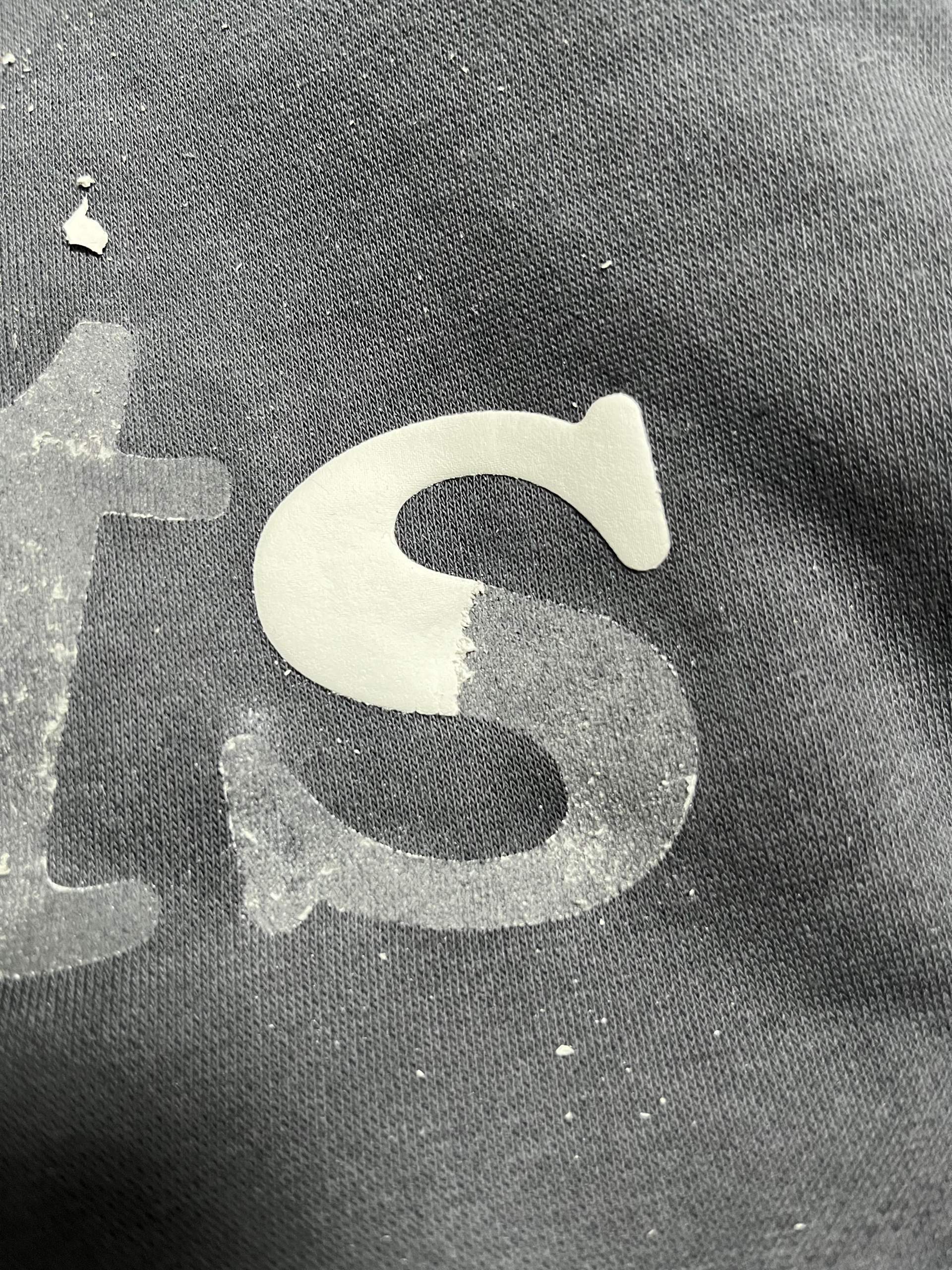 Wie kriegt man die Reste von Aufschriften bei Textilien raus? (Kleidung