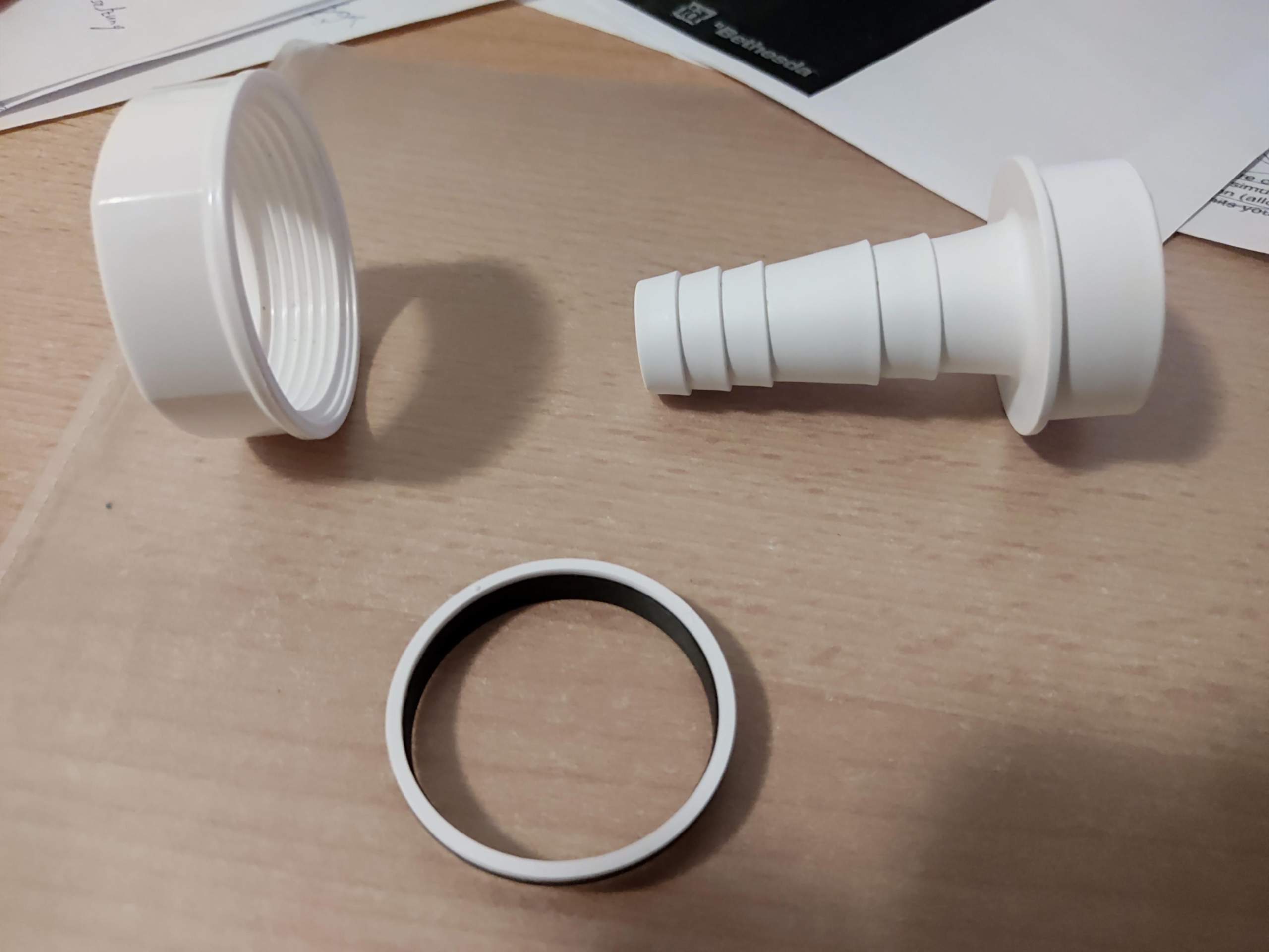 Wo kommt bei der Tülle für den Abwasserschlauch die Dichtung hin